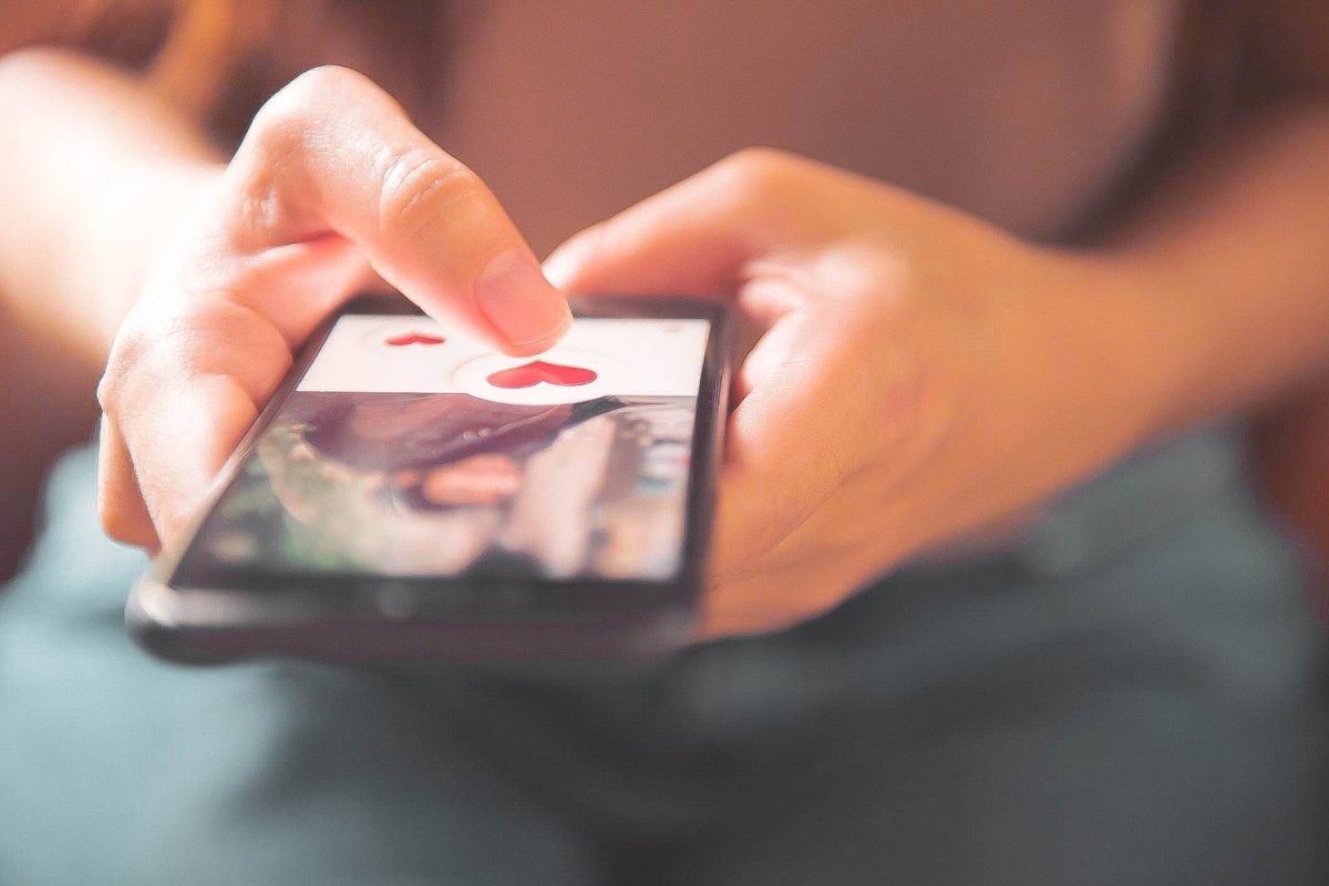 woman using online dating website on phone to find love, online dating during a lockdown